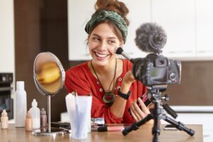 People, beauty, fashion and style concept. Portrait of positive joyful young female vblogger recordi